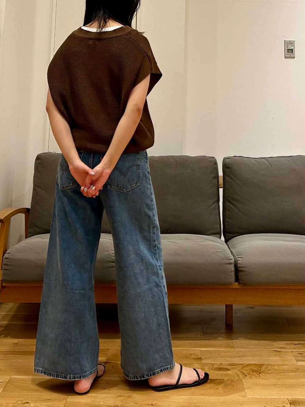 ホワイト系のタンクトップ、ブラウン系のベストを着用したレディースの夏コーディネートの3枚目の写真