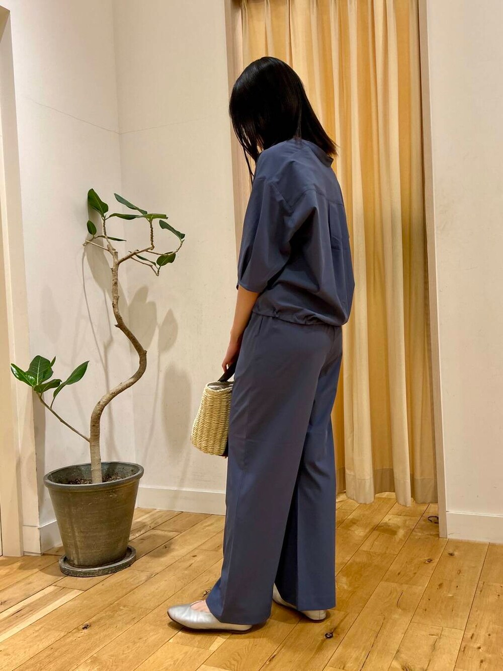 ベージュ系のかごバッグ、シルバー系のパンプス、ブルー系のシャツ/ブラウスを着用したレディースの春コーディネートの2枚目の写真