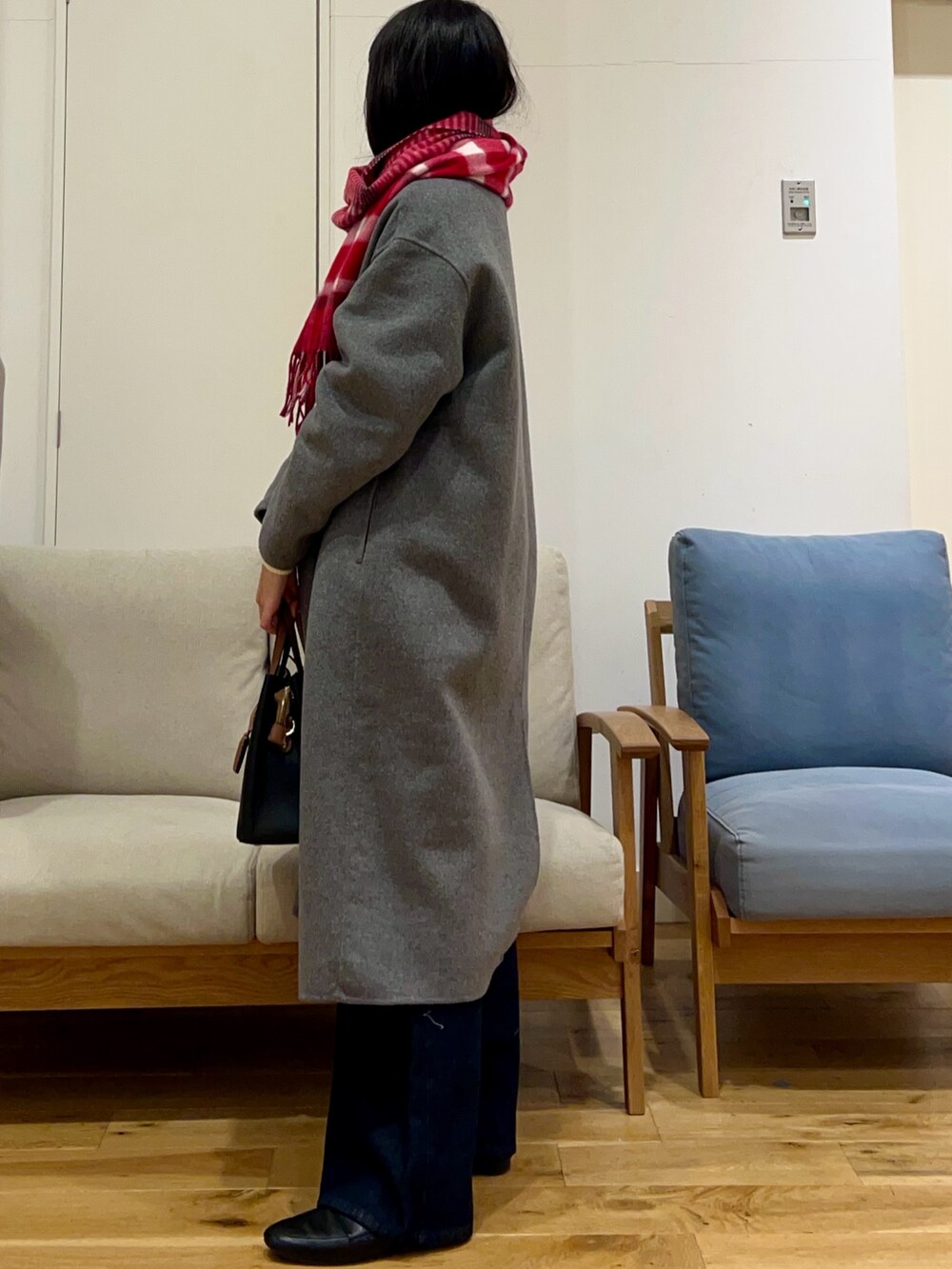 グレー系のその他アウター、ホワイト系のニット/セーター、ブルー系のデニムパンツを着用したレディースの冬コーディネートの2枚目の写真