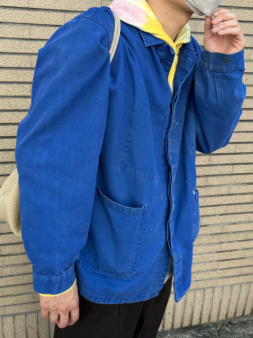 ブルー系のジャケット/アウター、ブラウン系のチノパンツ、ホワイト系のスニーカーを着用したメンズの秋コーディネートの2枚目の写真