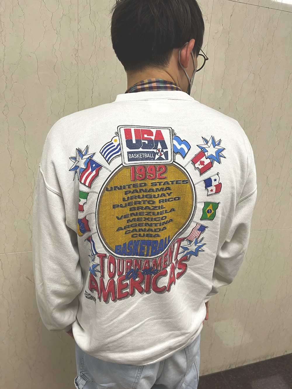 ブルー系のデニムパンツ、イエロー系のスニーカー、ホワイト系のスウェットを着用したメンズの冬コーディネートの3枚目の写真