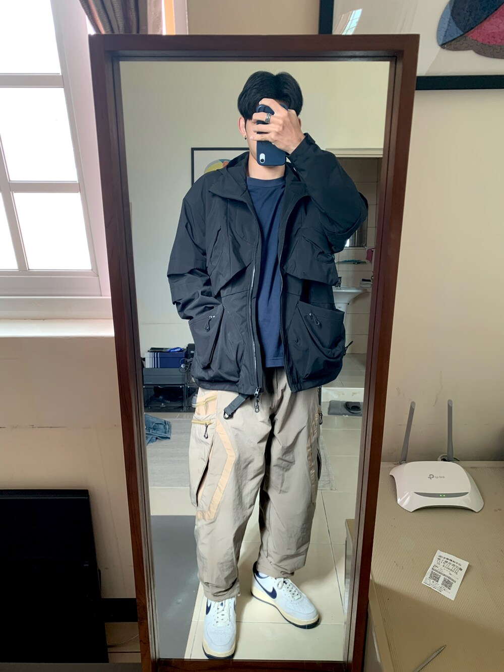 ブラック系のマウンテンパーカー、ベージュ系のその他パンツ、ブルー系のスニーカーを着用したメンズの冬コーディネートの3枚目の写真