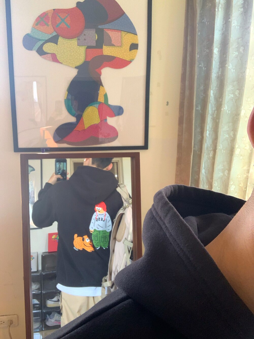 ホワイト系のスニーカー、ベージュ系のチノパンツ、ブラック系のパーカーを着用したメンズの冬コーディネートの2枚目の写真