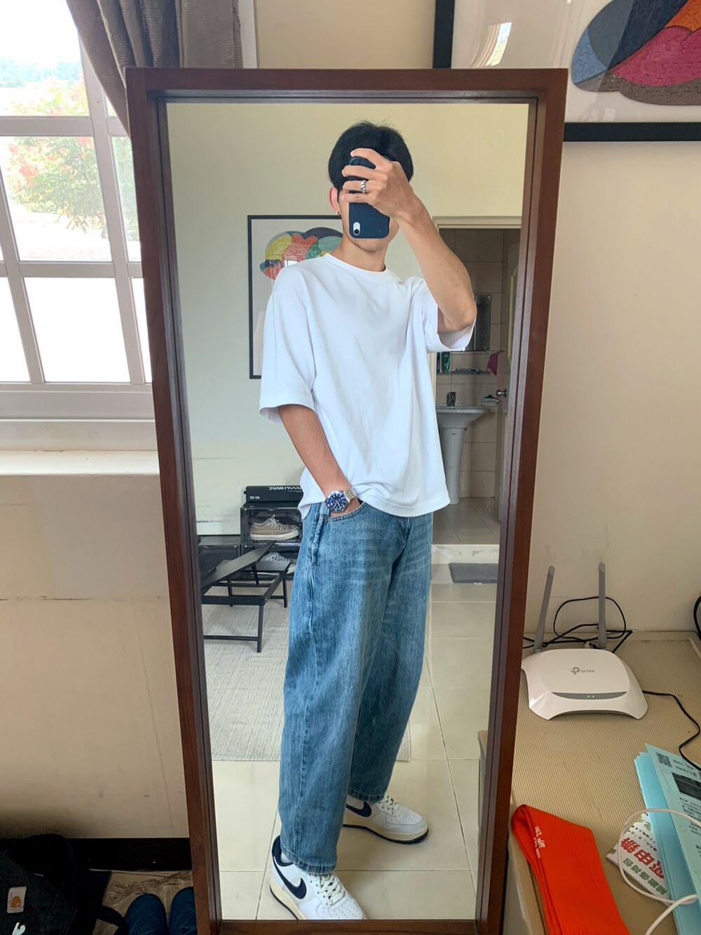 ブルー系のスニーカー、ブルー系のデニムパンツ、ホワイト系のTシャツ/カットソーを着用したメンズの秋コーディネートの2枚目の写真