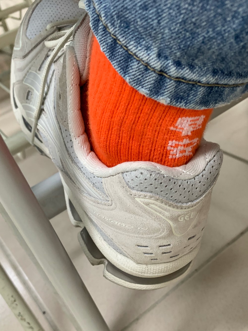 ホワイト系のTシャツ/カットソー、ブルー系のデニムパンツ、グレー系のスニーカーを着用したメンズの秋コーディネートの2枚目の写真