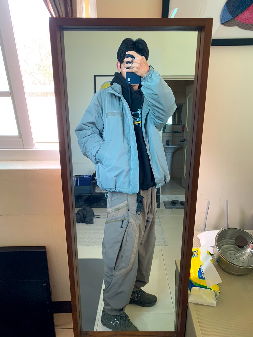 グリーン系のジャケット/アウター、ブラック系のパーカー、ベージュ系のバックパック/リュックを着用したメンズの冬コーディネートの2枚目の写真