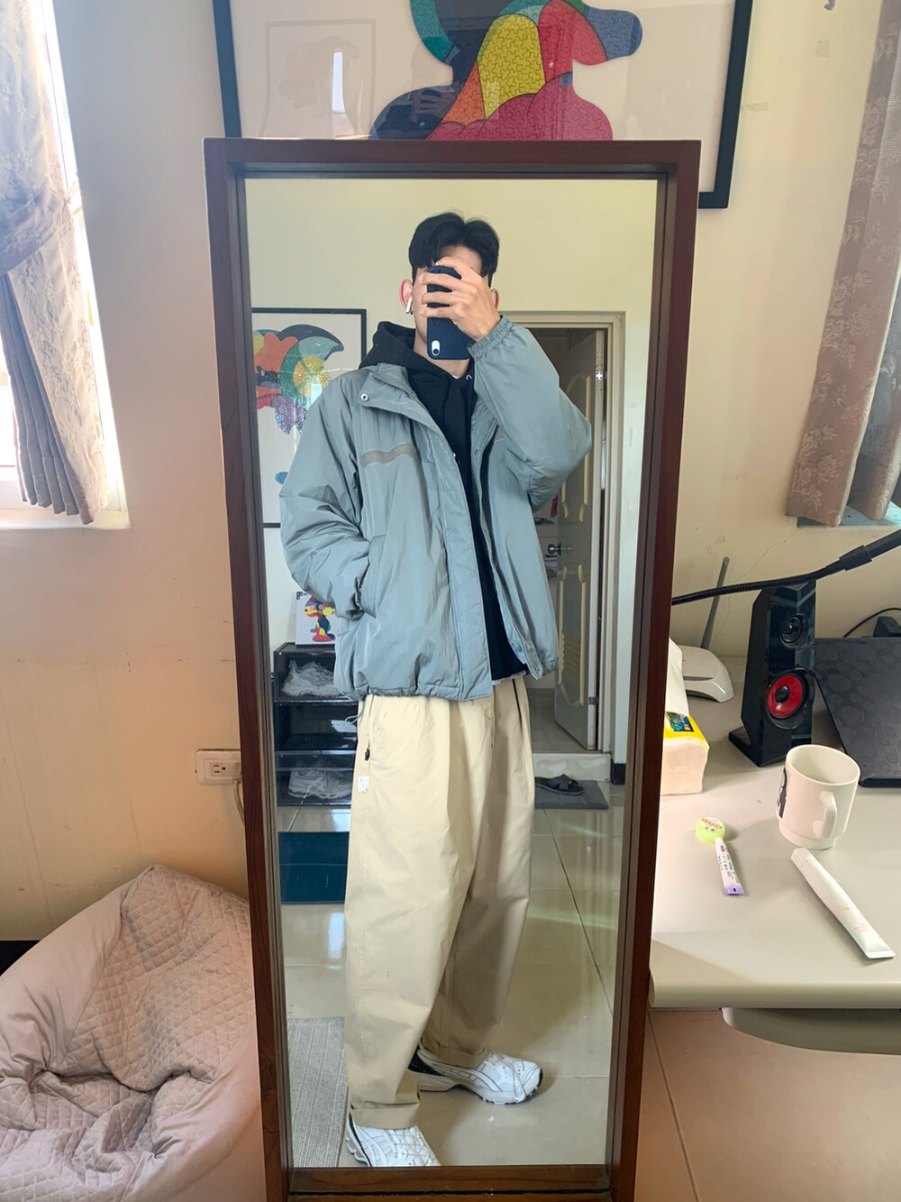 ホワイト系のスニーカー、ベージュ系のチノパンツ、ブラック系のパーカーを着用したメンズの冬コーディネートの3枚目の写真