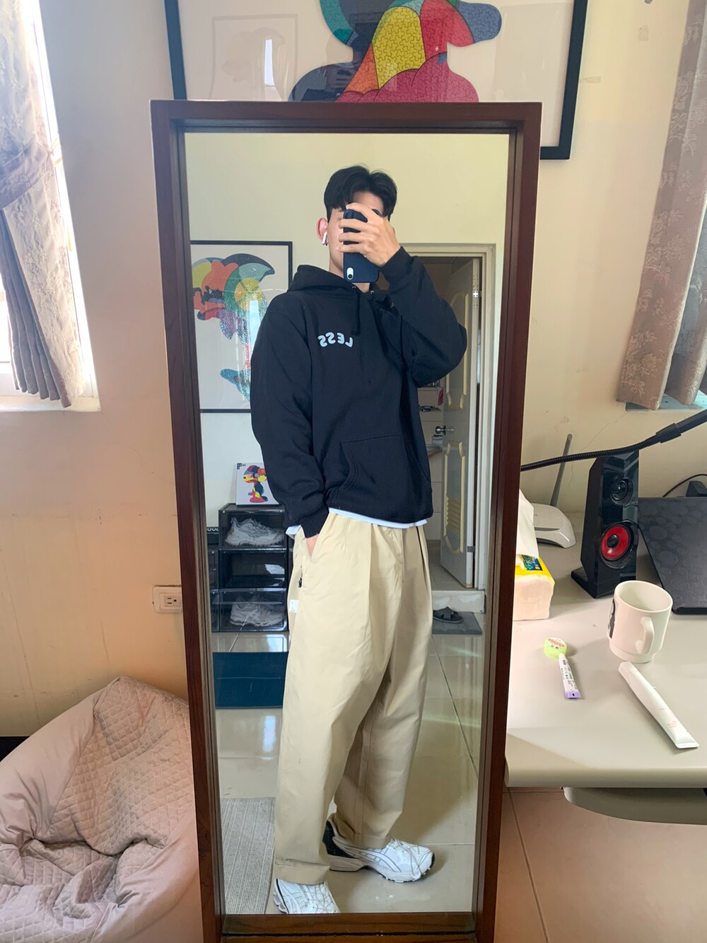 ホワイト系のスニーカー、ベージュ系のチノパンツ、ブラック系のパーカーを着用したメンズの冬コーディネートの4枚目の写真