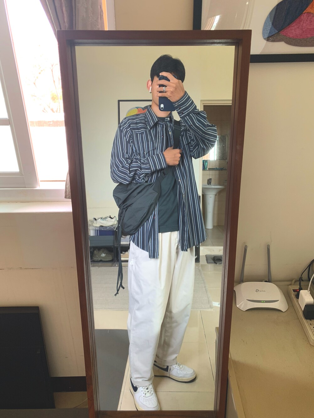 ブルー系のシャツ/ブラウス、グリーン系のTシャツ/カットソー、ホワイト系のチノパンツを着用したメンズの春コーディネートの2枚目の写真