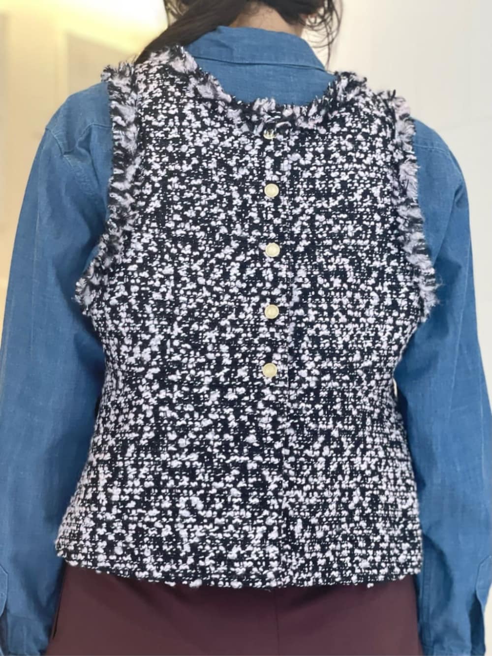 レッド系のスラックス、ブルー系のシャツ/ブラウス、ブラック系のベストを着用したレディースの秋コーディネートの3枚目の写真