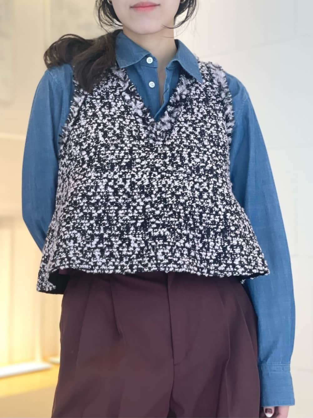 レッド系のスラックス、ブルー系のシャツ/ブラウス、ブラック系のベストを着用したレディースの秋コーディネートの2枚目の写真