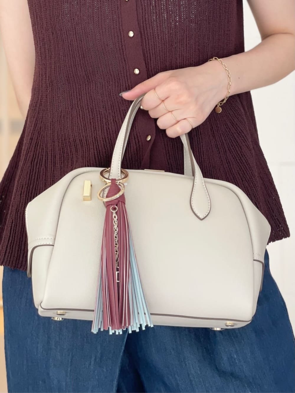 ブラウン系のニット/セーター、ブルー系のデニムパンツ、ブラウン系のパンプスを着用したレディースの夏コーディネートの2枚目の写真