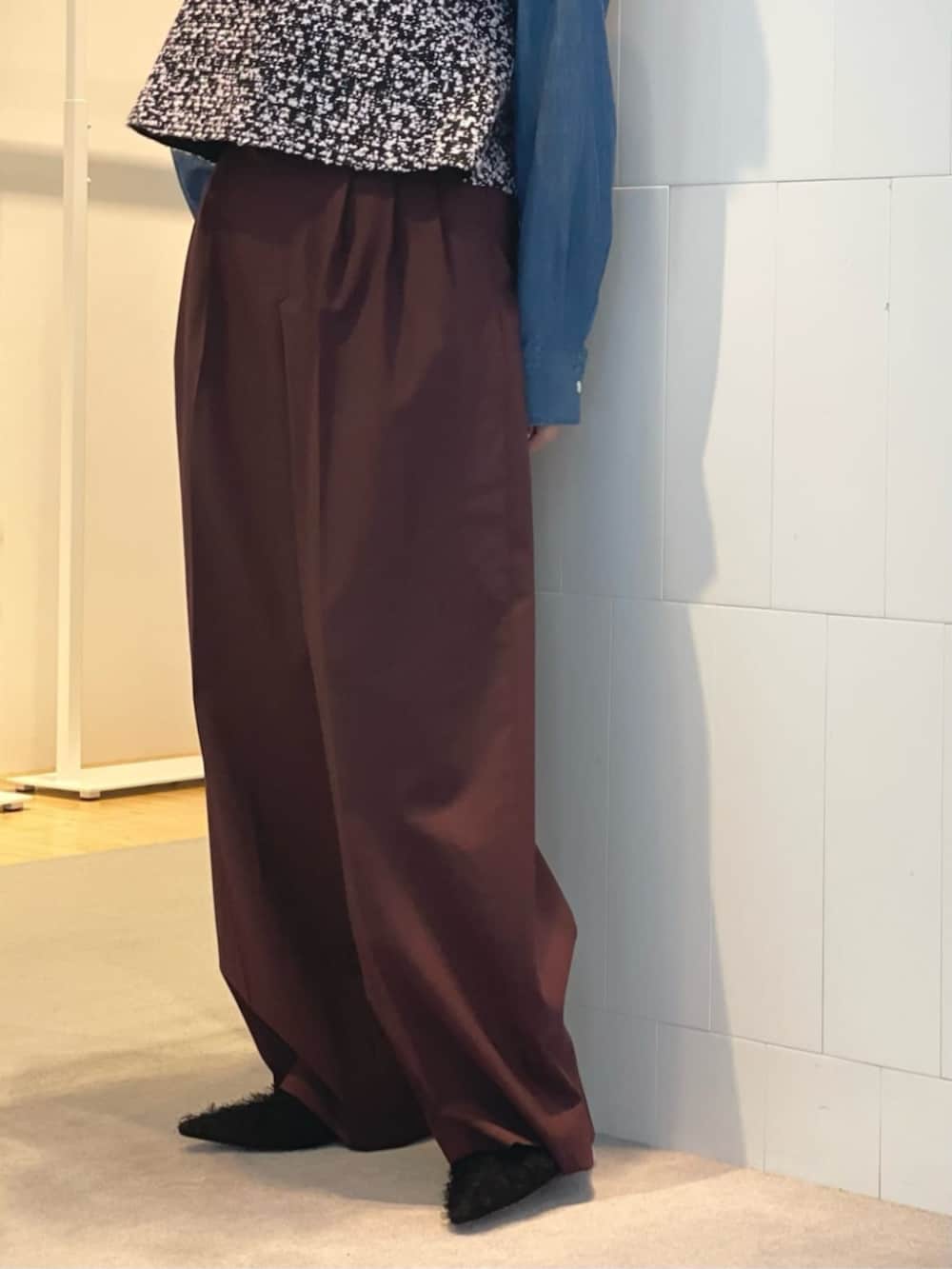 レッド系のスラックス、ブルー系のシャツ/ブラウス、ブラック系のベストを着用したレディースの秋コーディネートの5枚目の写真