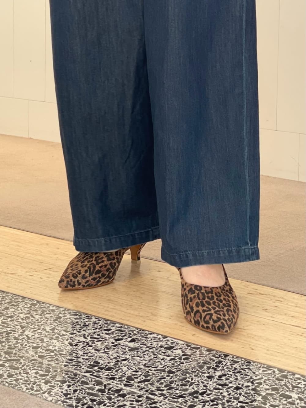 ブラウン系のニット/セーター、ブルー系のデニムパンツ、ブラウン系のパンプスを着用したレディースの夏コーディネートの5枚目の写真