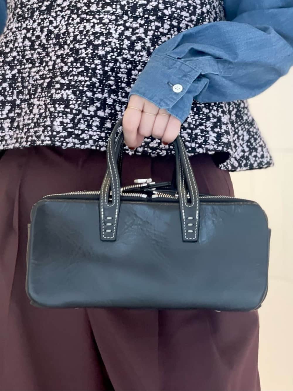 レッド系のスラックス、ブルー系のシャツ/ブラウス、ブラック系のベストを着用したレディースの秋コーディネートの4枚目の写真