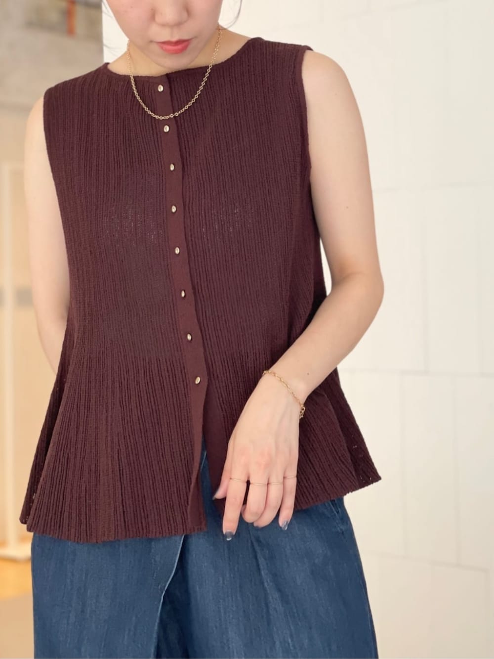 ブラウン系のニット/セーター、ブルー系のデニムパンツ、ブラウン系のパンプスを着用したレディースの夏コーディネートの3枚目の写真