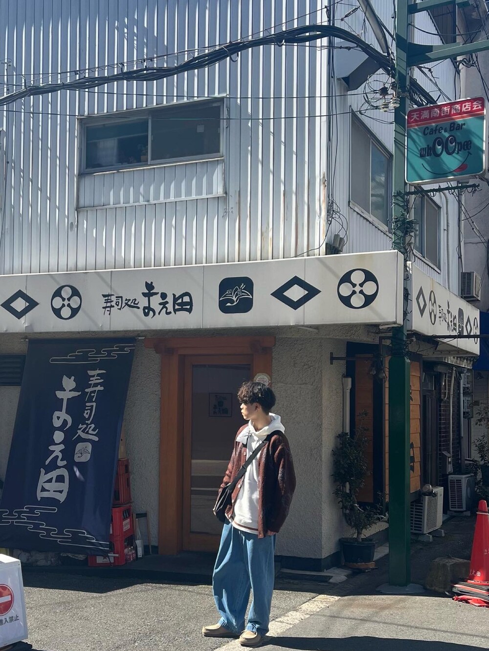 ブラウン系のカーディガン/ボレロ、ホワイト系のパーカー、ブルー系のデニムパンツを着用したメンズの春コーディネートの2枚目の写真