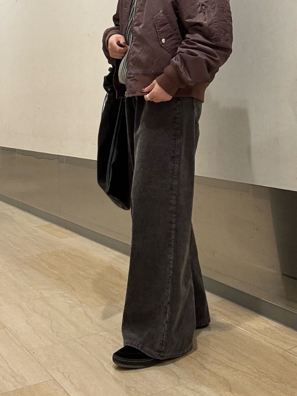 グレー系のニット/セーター、ブラック系のその他パンツ、ブラック系のショルダーバッグを着用したレディースの秋コーディネートの3枚目の写真