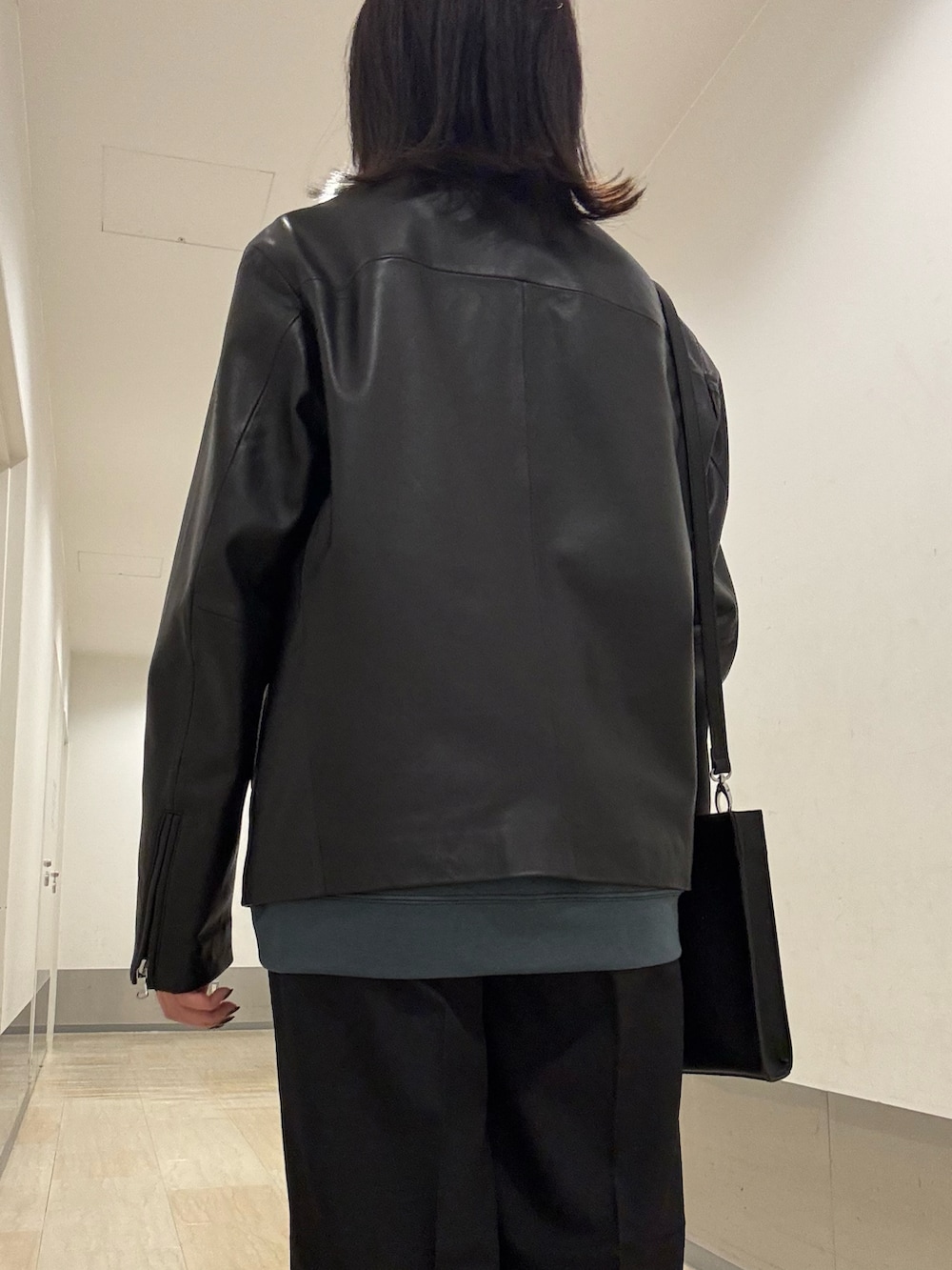 ブラック系のブルゾン、ブラック系のショルダーバッグ、ブラック系のその他パンツを着用したレディースの秋コーディネートの4枚目の写真