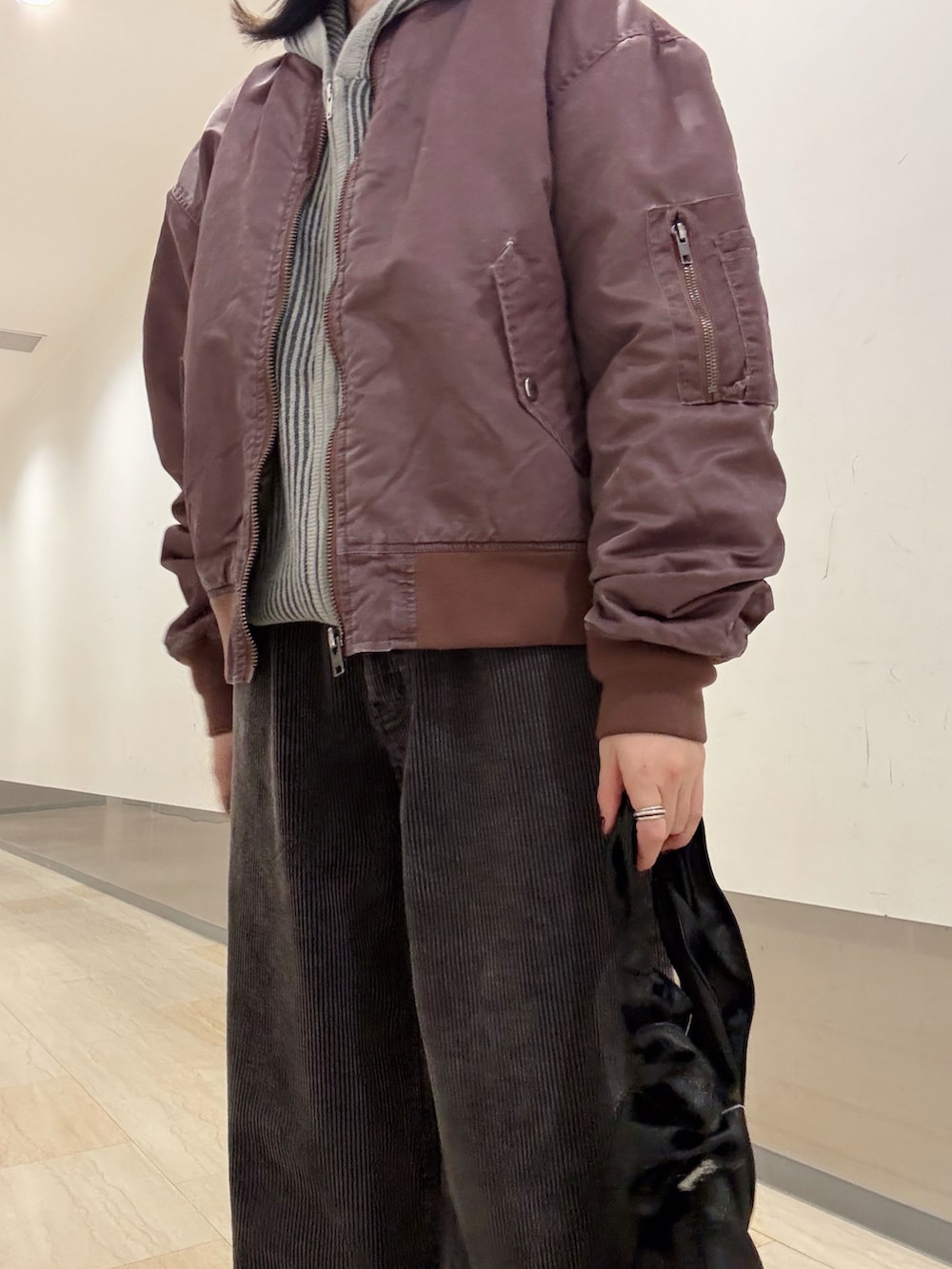 グレー系のニット/セーター、ブラック系のその他パンツ、ブラック系のショルダーバッグを着用したレディースの秋コーディネートの2枚目の写真