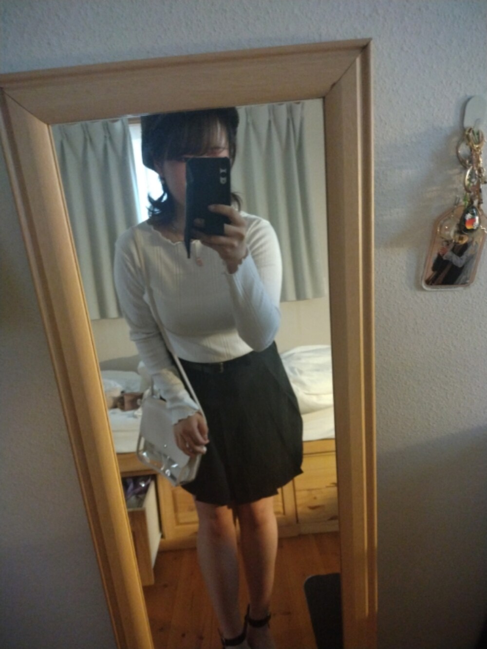 ブラック系のシューズ、ホワイト系のニット/セーター、グレー系のトップスを着用したレディースの春コーディネートの2枚目の写真