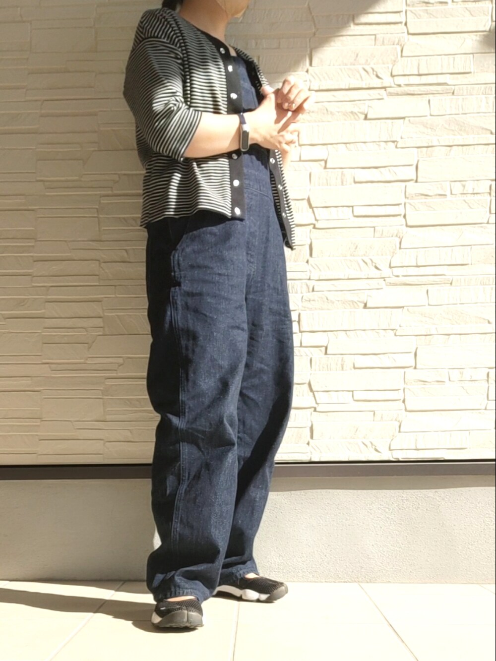 ブラック系のアンサンブル、ブルー系のサロペット/オーバーオール、ブラック系のサンダルを着用したレディースの秋コーディネートの2枚目の写真