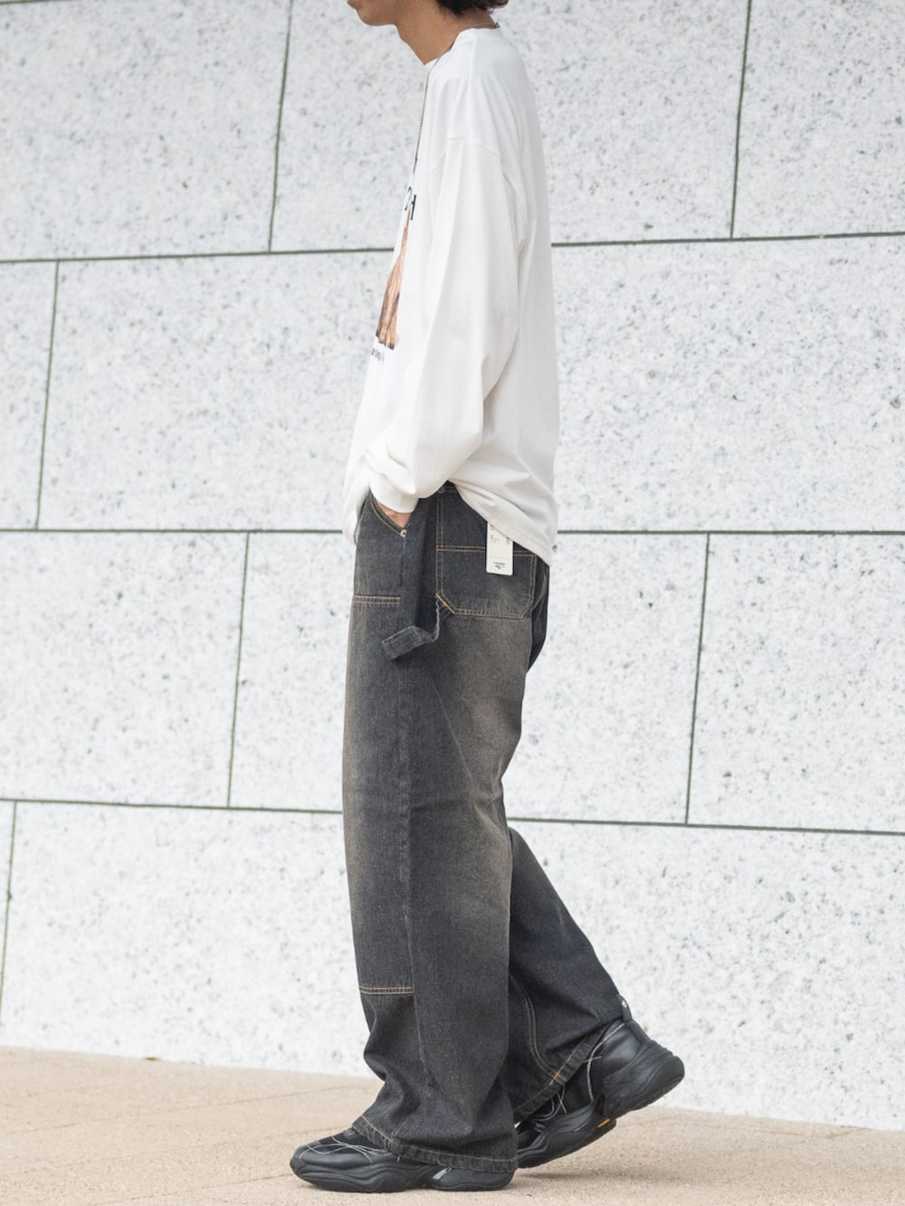 ブラック系のデニムパンツ、ホワイト系のTシャツ/カットソーを着用したメンズの秋コーディネートの2枚目の写真
