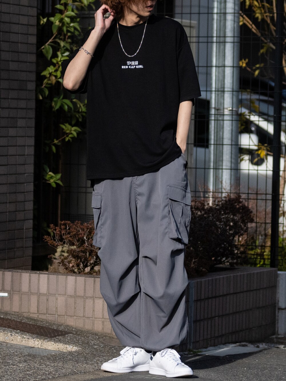 グレー系のカーゴパンツ、ホワイト系のスニーカー、ブラック系のTシャツ/カットソーを着用したメンズの春コーディネートの2枚目の写真
