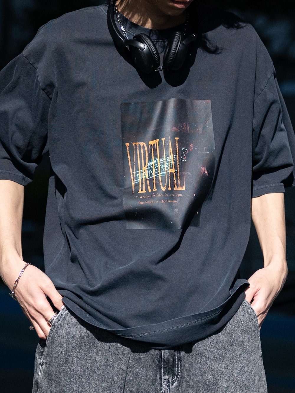 ブラック系のカーゴパンツ、ホワイト系のスニーカー、ブラック系のTシャツ/カットソーを着用したメンズの春コーディネートの2枚目の写真