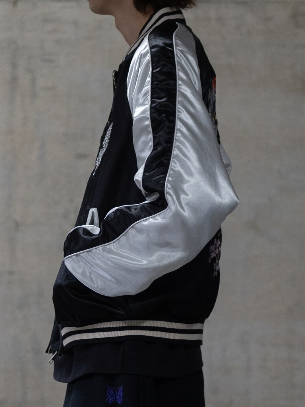 ブラック系のカーゴパンツ、ブラック系のスカジャンを着用したメンズの春コーディネートの4枚目の写真