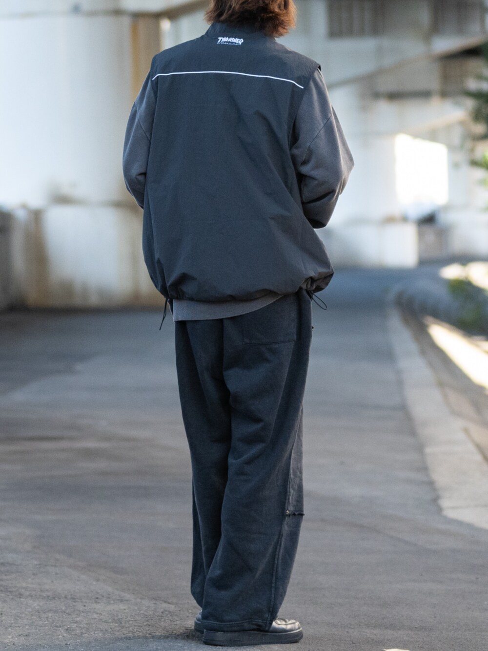 ブラック系のスウェット、グレー系のベスト、ブラック系のスニーカーを着用したメンズの冬コーディネートの3枚目の写真