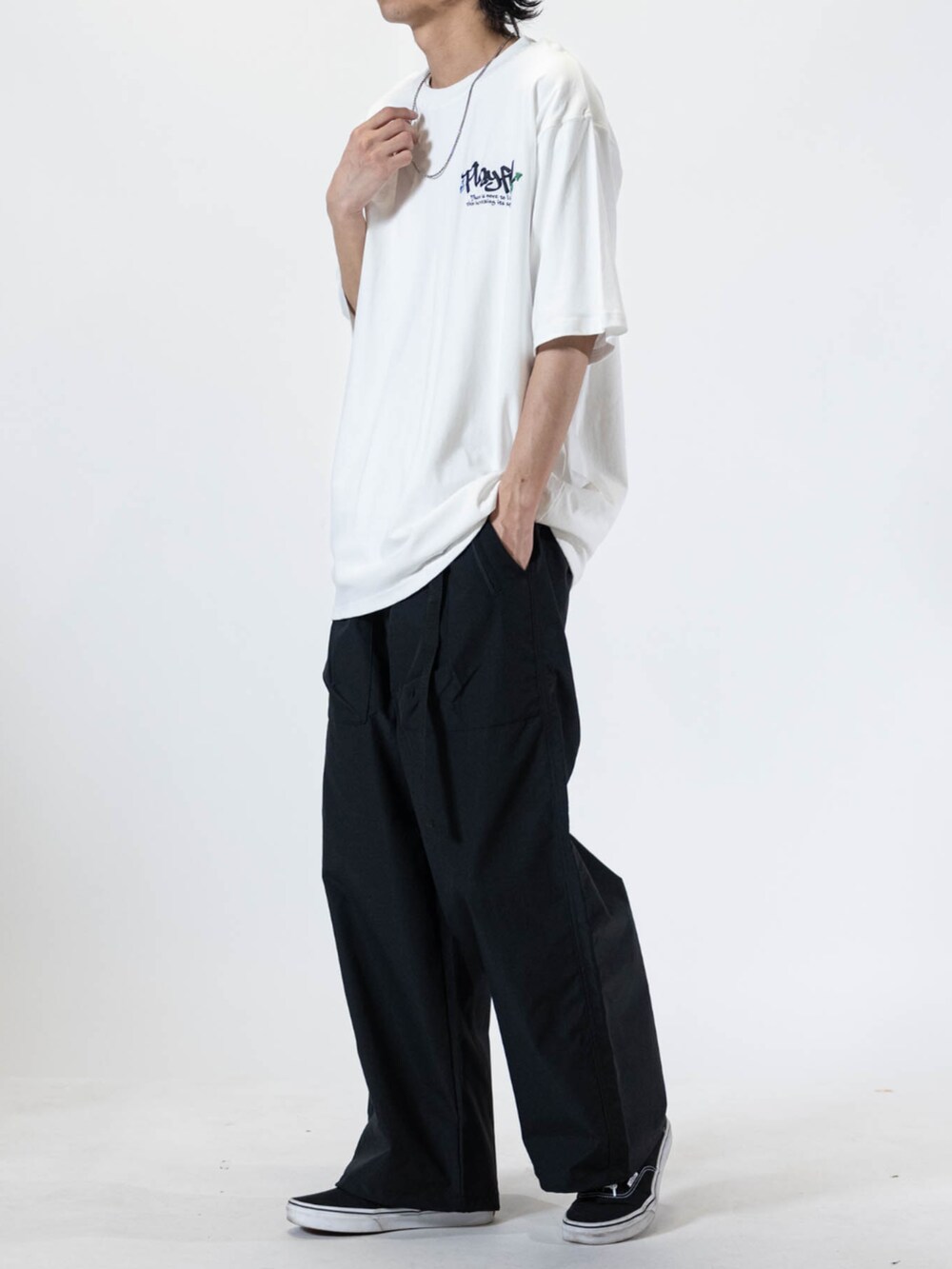 ブラック系のスニーカー、グリーン系のチノパンツ、ホワイト系のTシャツ/カットソーを着用したメンズの夏コーディネートの2枚目の写真