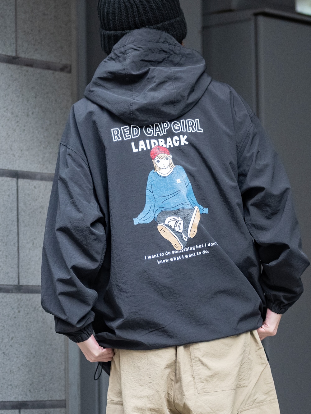 ベージュ系のカーゴパンツ、ブラック系のナイロンジャケットを着用したメンズの春コーディネートの3枚目の写真