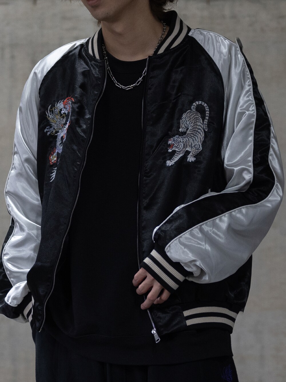 ブラック系のカーゴパンツ、ブラック系のスカジャンを着用したメンズの春コーディネートの5枚目の写真