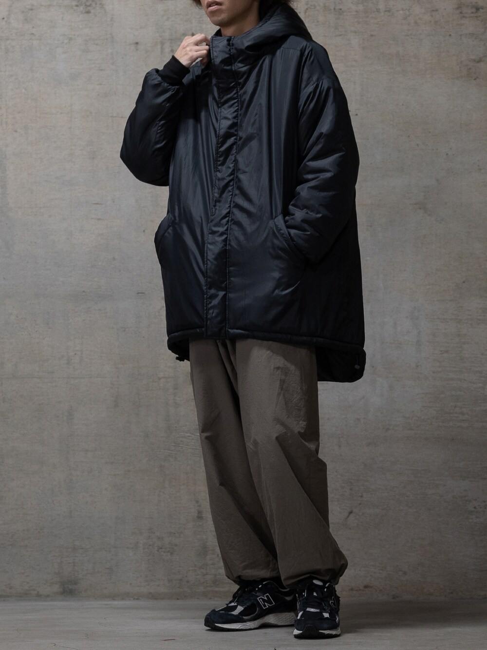 ブラック系のスニーカー、ブラック系のミリタリージャケットを着用したメンズの秋コーディネートの2枚目の写真