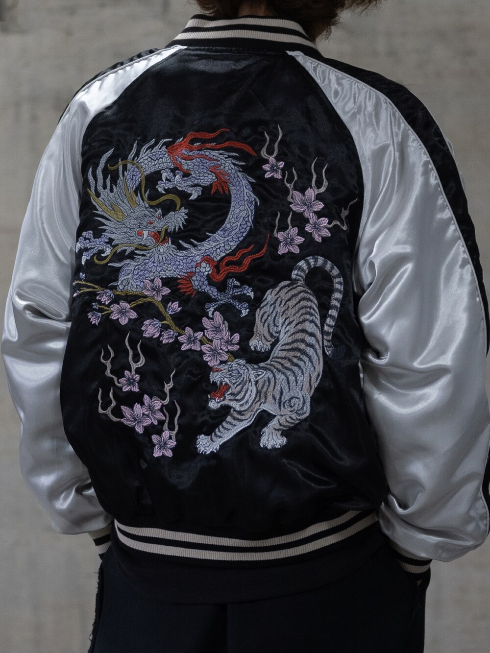 ブラック系のカーゴパンツ、ブラック系のスカジャンを着用したメンズの春コーディネートの3枚目の写真