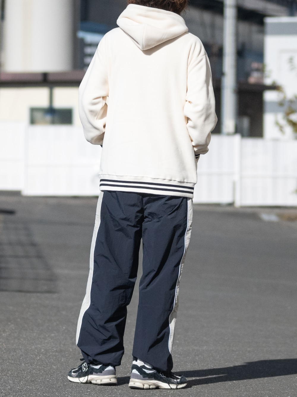 ブラック系のスニーカー、ブルー系のその他パンツ、ホワイト系のパーカーを着用したメンズの冬コーディネートの3枚目の写真