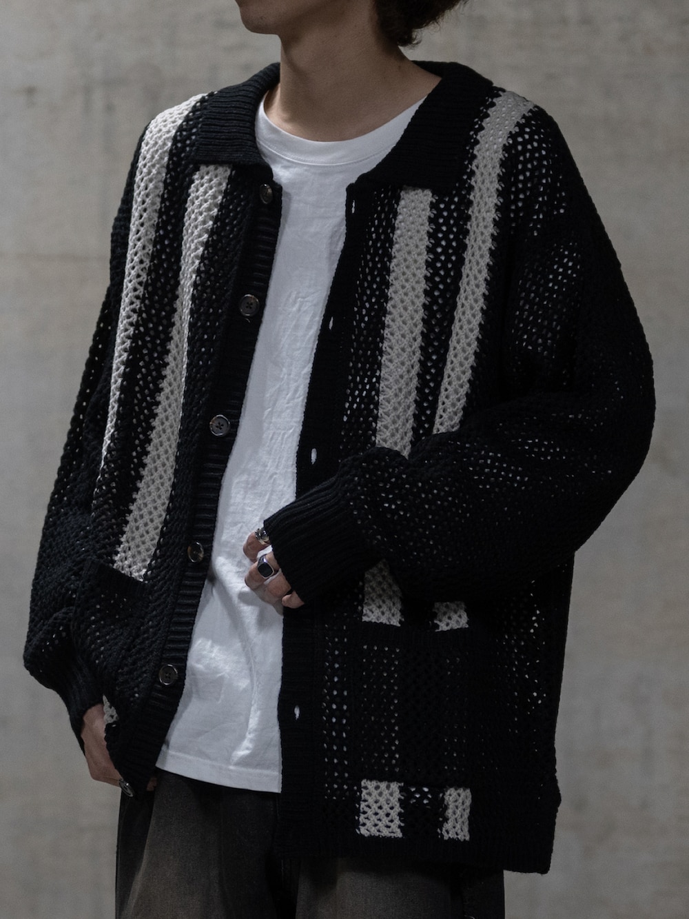 ブラック系のカーディガン/ボレロ、ブラック系のデニムパンツを着用したメンズの冬コーディネートの2枚目の写真