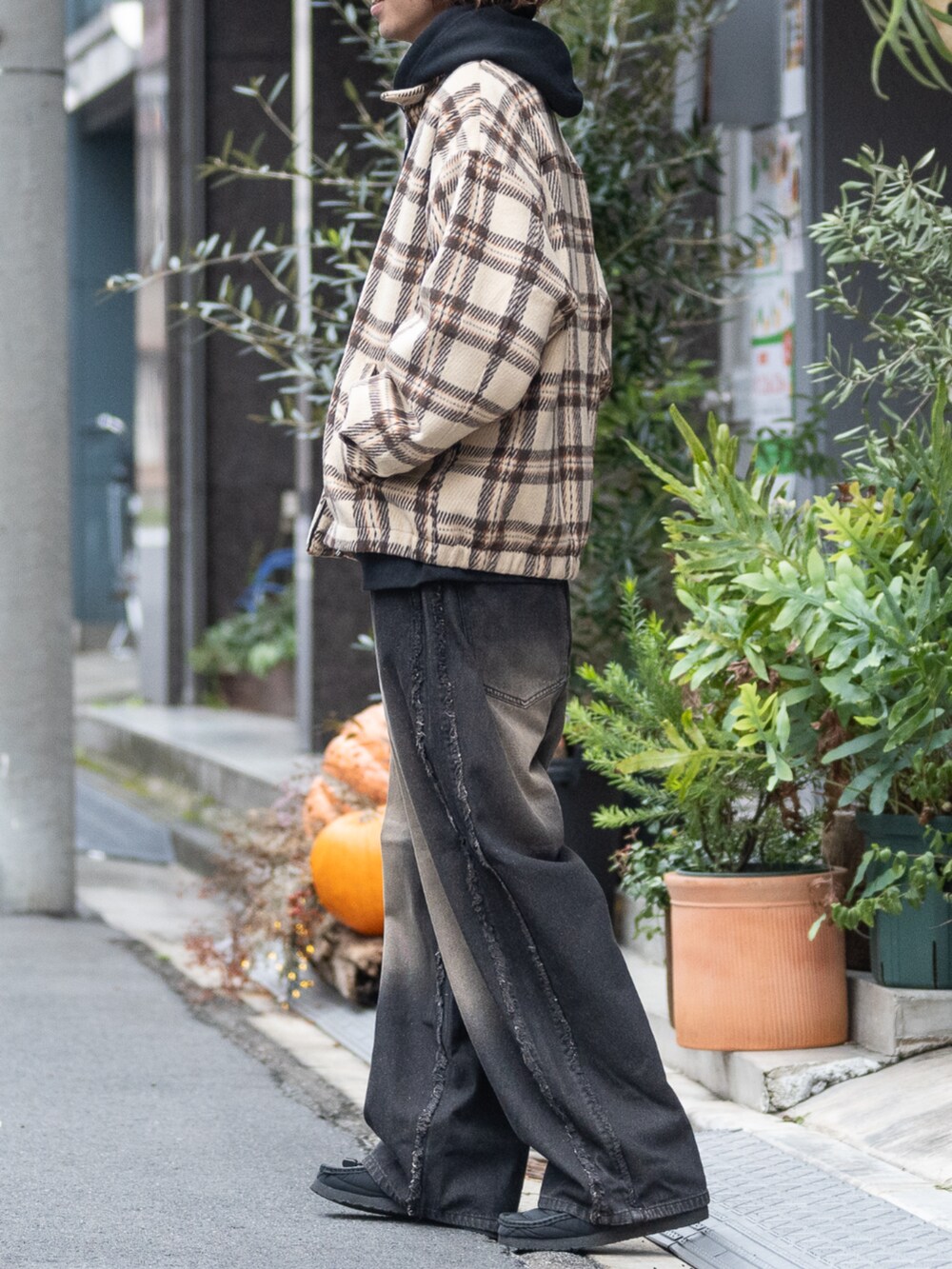 ブラウン系のブルゾン、ブラウン系のデニムパンツ、ブラック系のパーカーを着用したメンズの冬コーディネートの2枚目の写真