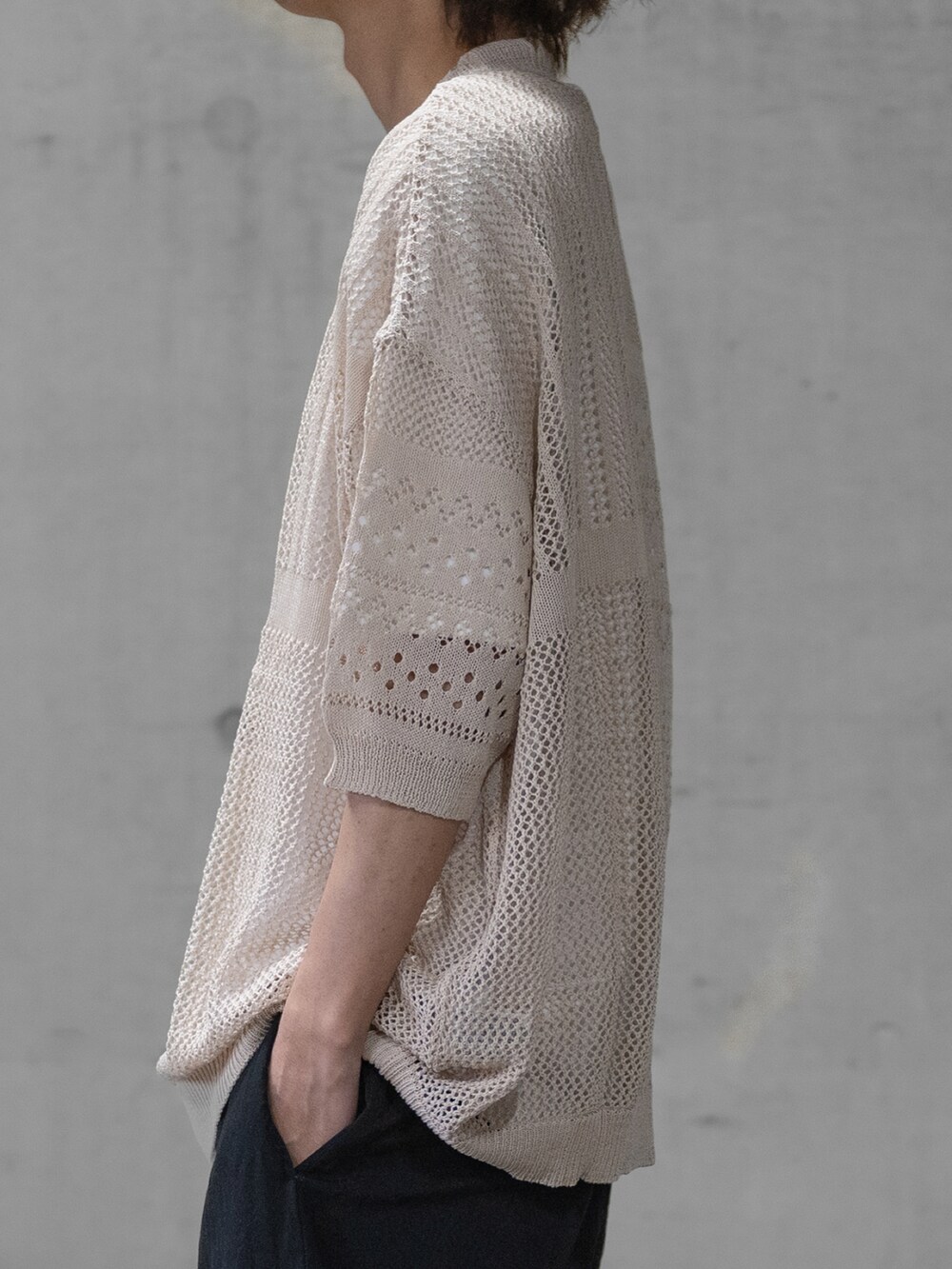 ブラック系のニット/セーター、ブラック系のデニムパンツ、ブラック系のドレスシューズを着用したメンズの春コーディネートの3枚目の写真