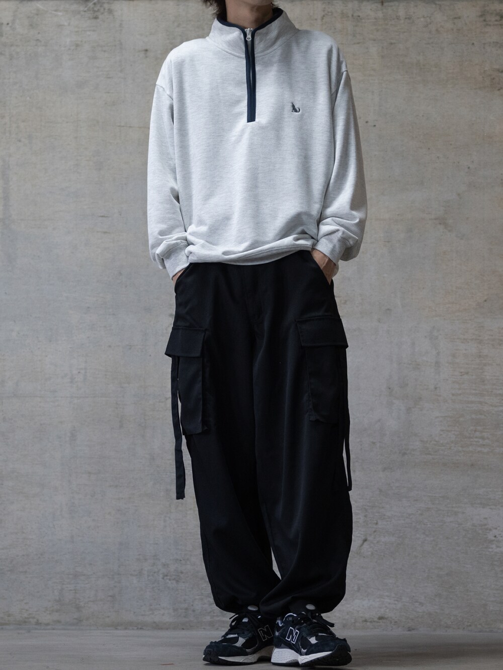 ブラック系のスニーカー、グリーン系のカーゴパンツ、グレー系のスウェットを着用したメンズの秋コーディネートの2枚目の写真