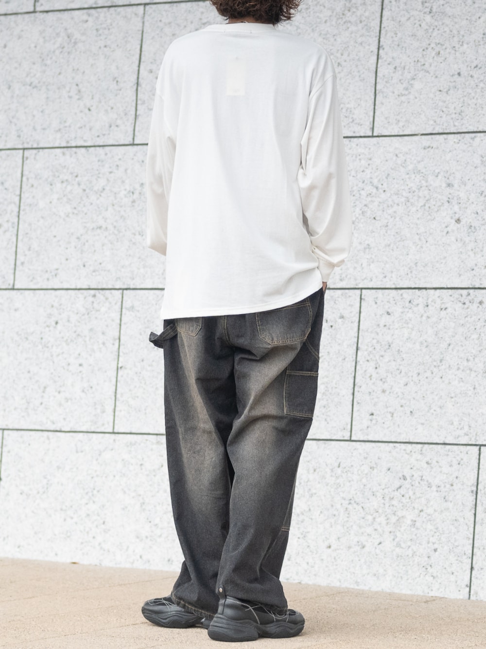 ブラック系のデニムパンツ、ホワイト系のTシャツ/カットソーを着用したメンズの秋コーディネートの3枚目の写真
