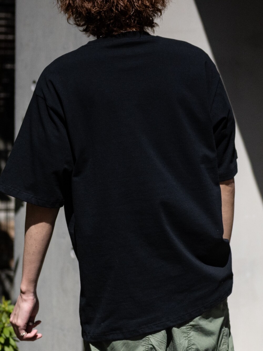 ホワイト系のスニーカー、ブラック系のTシャツ/カットソー、その他のネックレスを着用したメンズの春コーディネートの4枚目の写真