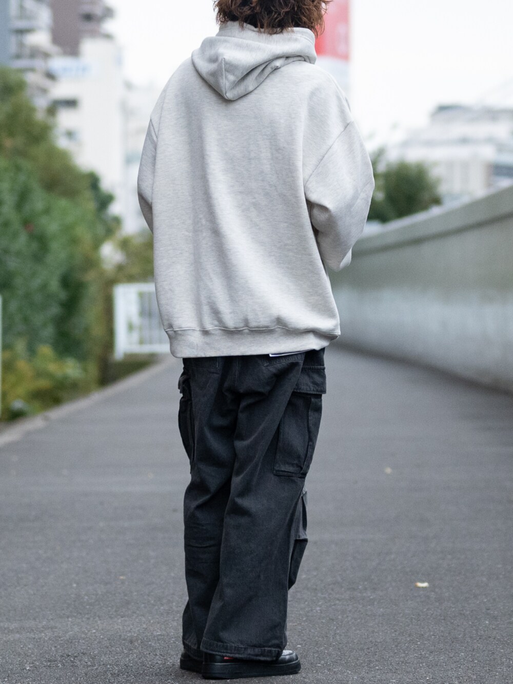 ブラック系のデニムパンツ、ベージュ系のパーカーを着用したメンズの冬コーディネートの3枚目の写真