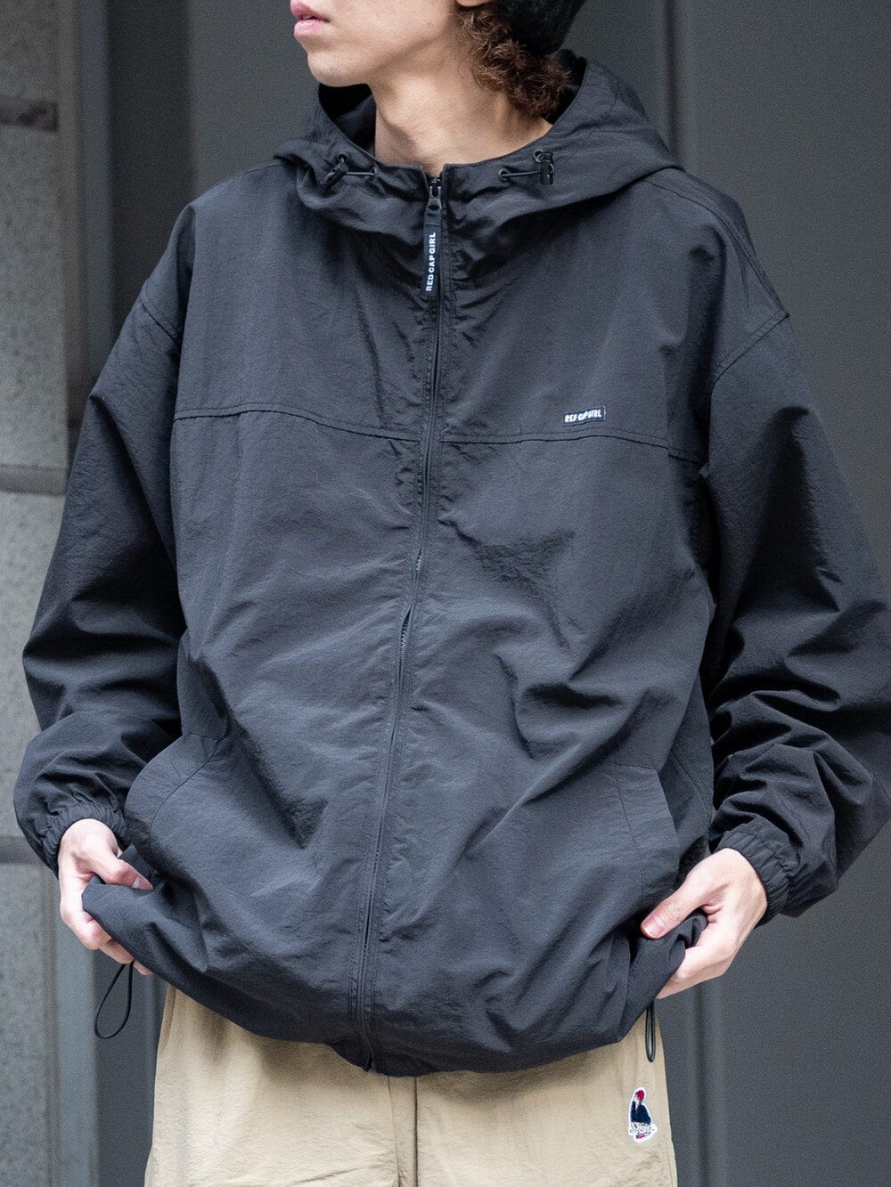 ベージュ系のカーゴパンツ、ブラック系のナイロンジャケットを着用したメンズの春コーディネートの5枚目の写真