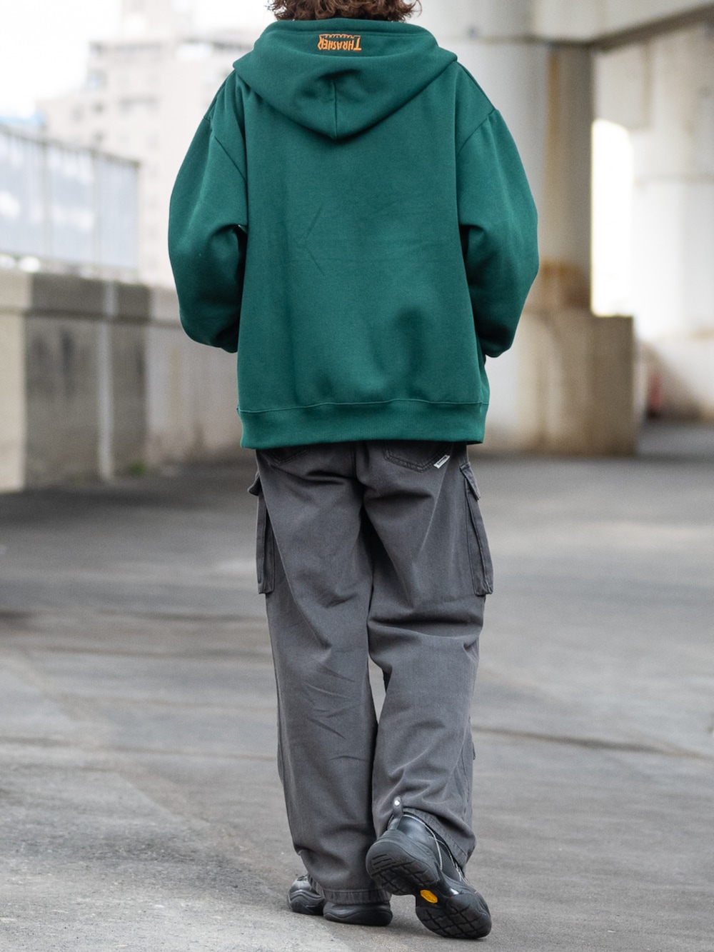 ブラック系のデニムパンツ、グリーン系のパーカーを着用したメンズの秋コーディネートの3枚目の写真