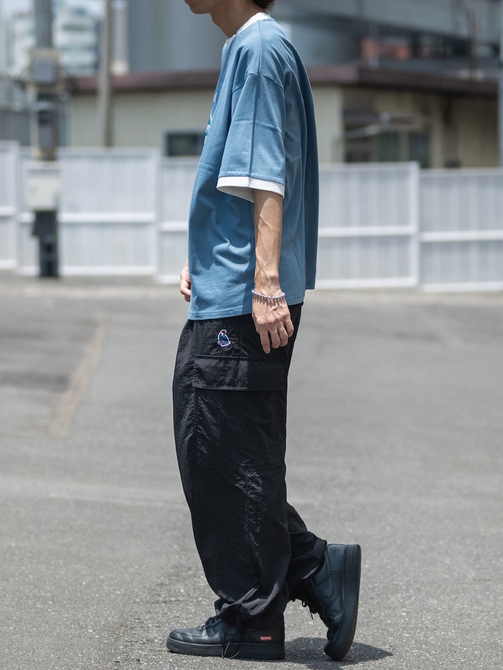 ブラック系のカーゴパンツ、ブルー系のTシャツ/カットソーを着用したメンズの夏コーディネートの2枚目の写真