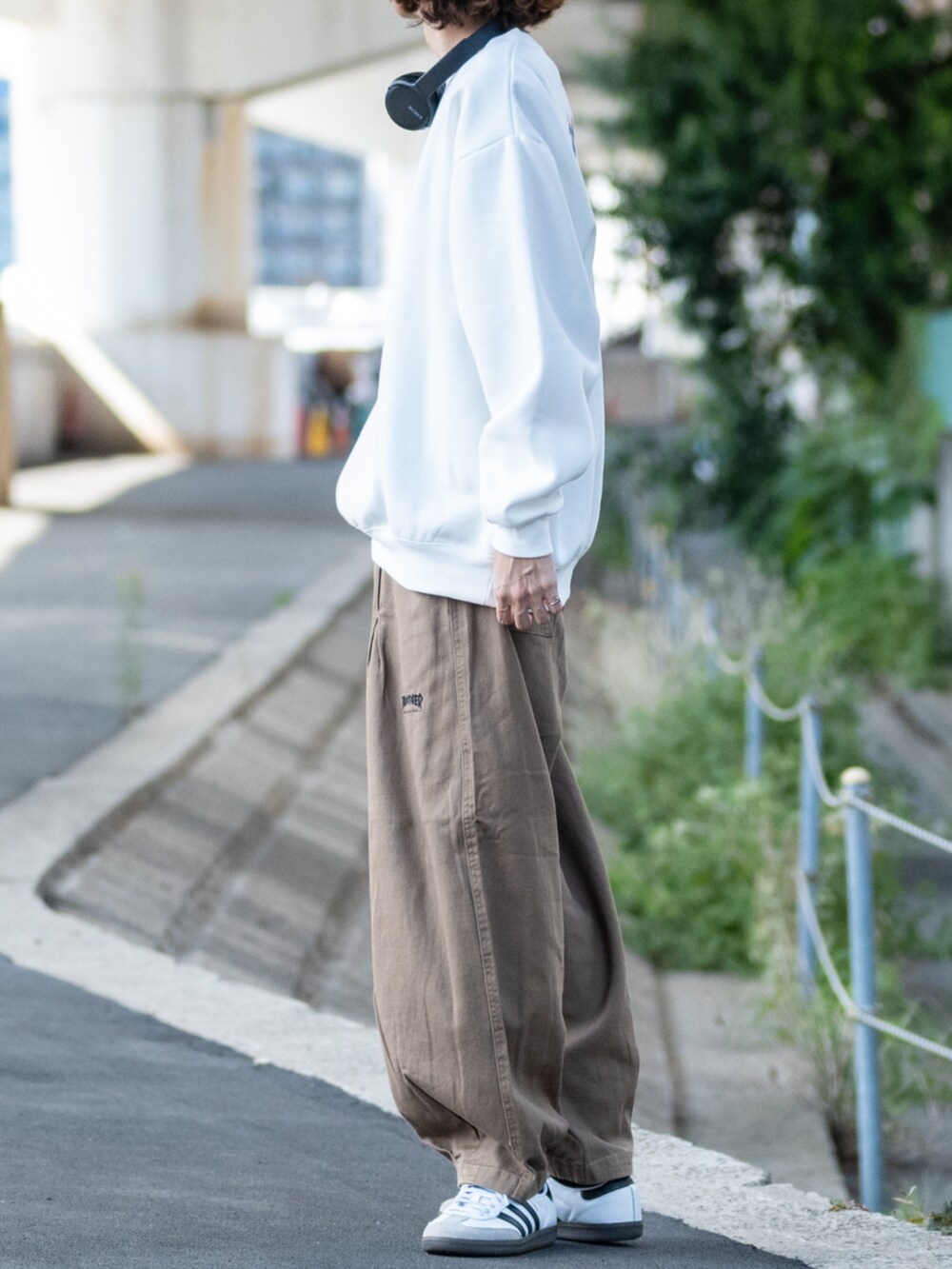 ホワイト系のスニーカー、ベージュ系のデニムパンツ、ホワイト系のスウェットを着用したメンズの秋コーディネートの2枚目の写真