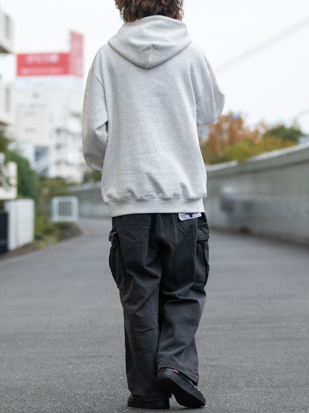 ブラック系のデニムパンツ、グレー系のパーカーを着用したメンズの冬コーディネートの3枚目の写真