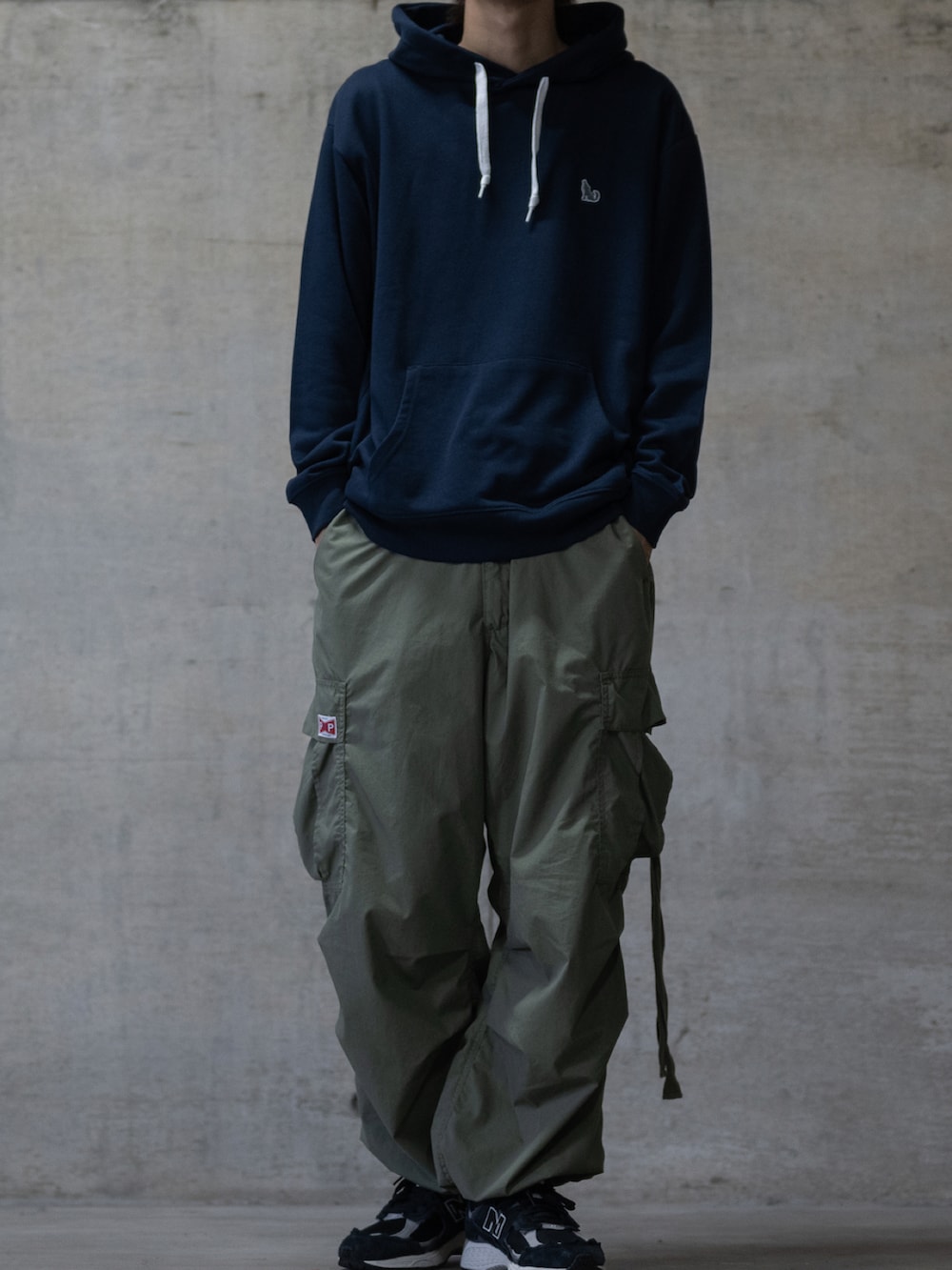 ブラック系のスニーカー、グリーン系のカーゴパンツ、ブルー系のパーカーを着用したメンズの冬コーディネートの2枚目の写真